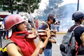 Muž hraje uprostřed zuřící venezuelské demonstrace na housle