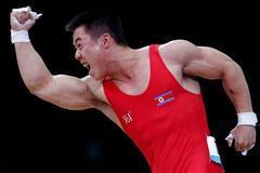Severokorejský vzpěrač Guk Kim Un se raduje ze světového rekordu mužů do 62 kg na OH 2012 v Londýně.