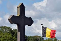 Kříž a belgická vlajka na hřbitově v Mouscronu.