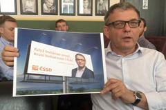 Lubomír Zaorálek ukazuje nový billboard na volební kampaň
