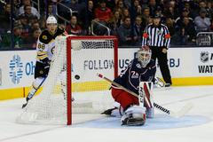 David Pastrňák sleduje, jak po jeho asistenci končí puk za zády brankáře Columbusu Sergeje Bobrovského