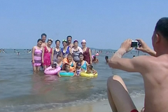 Cestování do Severní Koreje. Na odpalové pláži se sluní turisté
