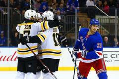 David Pastrňák v klubku spoluhráčů z Bostonu Bruins