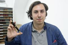 Jan Novák ukazuje výsledek své práce, psací pero s dřevěnou násadou.