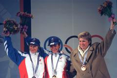 Kateřina Neumannová v kabátu na stupních vítězů na olympijských hrách v Naganu s Ruskami Larisou Lazutinovou a Olgou Danilovovou