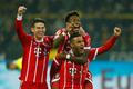 Fotbalisté Bayernu slaví gól v síti Dortmundu