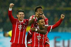Fotbalisté Bayernu slaví gól v síti Dortmundu