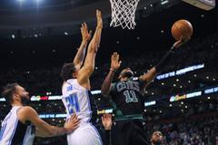 Hvězda Bostonu Kyrie Irving se snaží skórovat přes bránícího Khema Birche v utkání NBA