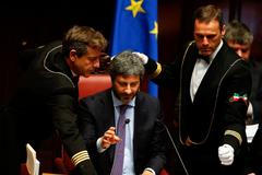 Asistenti kontrolují mikrofon nově zvoleného předsedy italské Poslanecké sněmovny Roberta Fica