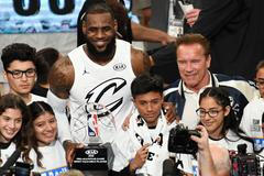 LeBron James pózuje s dětmi, cenou pro nejužitečnějšího hráče Utkání hvězd a Arnoldem Schwarzeneggerem