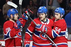 Obránce Montrealu Jakub Jeřábek (vlevo) slaví s Jonathanem Drouinem (uprostřed) a Charlesem Hudonem gól v síti Islanders