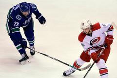 Elias Lindholm (Carolina Hurricanes) a Vancouver Canucks (Alexander Edler)