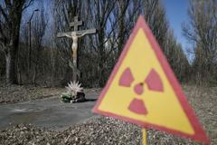 Kristus na kříži a značka upozorňující na radiaci u opuštěného města Pripjať nedaleko Černobylu.