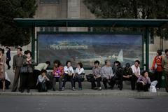 Lidé na autobus. zastávce v Pchjongjangu