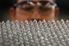 Zaměstnanec kontroluje halogenové žárovkdy s nízkou spotřebou