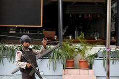 Indonéský policista u kavárny zničené výbuchem.