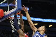 Markieff Morris (5) z Washingtonu bráněný hráčem Orlanda Aaronem Gordonem (00) .