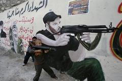 Palestinský chlapec si hraje na vojáky