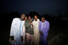 Muži v Maiduguri poslouchají rozhlas krátce po oznámení posunutí voleb.