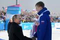 Prezident Vladimir Putin gratuluje na univerziádě v Krasnojarsku při slavnostním ceremoniálu po závodě běžců na 10 kilometrů ruským sportovcům, kteří obsadili všechna tři místa na stupních vítězů...