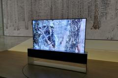 Chytrá rolovací televize ve stojanu. OLED TV s pružnou obrazovkou se přizpůsobí fotmátu videa