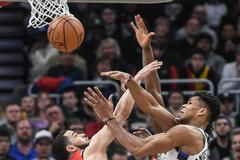 Giannis Antetokounmpo (34) z Milwaukee bojuje o míč s hráčem Toronta Fredem VanVleetem.