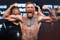 FILE PHOTO: UFC lightweight champion Conor McGregor of Ireland poses on the scale during his official weigh-in at T-Mobile Arena in Las Vegas