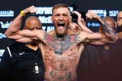 FILE PHOTO: UFC lightweight champion Conor McGregor of Ireland poses on the scale during his official weigh-in at T-Mobile Arena in Las Vegas