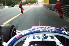 Traťoví komisaři v Monaku přebíhají přes trať před monopostem Racing Point Segia Péreze.