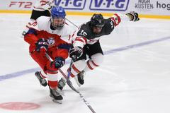 Český hokejista Filip Přikryl bojuje na mistrovství světa hráčů do 18 let o puk s Kanaďanem Alexem Newhookem