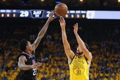 Lou Williams (vlevo) z LA Clippers blokuje střelu Stephena Curryho, hvězdy Golden State