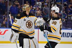 Útočník David Pastrňák slaví s brankářem Tuukkou Raskem vítězství v šestém utkání finálové série Stanley Cupu proti St. Louis