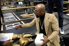 Floyd Mayweather signs gloves at the opening of the Mayweather Boxing + Fitness gym in Torrance