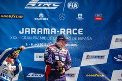 Pilot Buggyry Adam Lacko dostává po vítězství v prvním nenedělním závodě v Jaramě spršku šampaňským od staronového šampiona Jochena Hahna