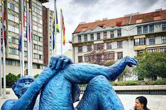 Socha opice s obřími zlatými varlaty vyvádí z míry turisty před hotelem Intercontinental