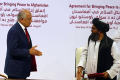 Zástupci USA a Tálibánu při podpisu dohody v Kataru.