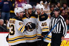 David Pastrňák (88) celebrates his goal with left wing Brad Marchand (63) and center David Krejčí (46)