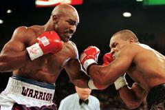 FILE PHOTO: WBA Heavyweight Champion Evander Holyfield (R) connects to the jaw of challenger Mike Tyson in the f..
