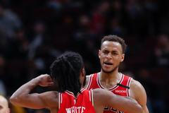 Hráči Bulls Coby White (0) a Daniel Gafford (12) slaví v zápase s Dallasem