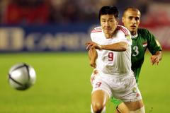 FILE PHOTO: China's striker Hao haidong and Iraq's Basim Abbas chase a loose ball...
