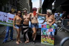 Women pose for a picture before starting a topless march in New York