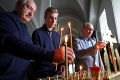 Alexandr Lukašenko a Vladimir Putin v pravoslavném chrámu. Uprostřed stojí Lukašenkův syn Nikolaj.
