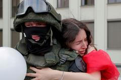 Tuto fotografii vybrala agentura Reuters mezi nejlepší snímky roku 2020. Demonstrantka 14.srpna objímá před budovou vlády v Minsku příslušníka speciálních jednotek.