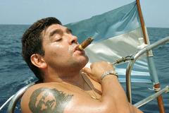 FILE PHOTO: Argentine World Cup winner Diego Maradona smokes a cigar in the waters off Havana, Cuba