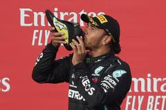 Lewis Hamilton pije z boty Daniela Ricciarda po závodě F1 v Imole