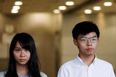 Zadržení aktivisté z Hongkongu Agnes Chowová a Joshua Wong.