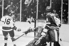 Americký hokejista Mark Pavelich střílí druhý gól do sítě Jiřího Králíka, vpravo Milan Nový v zápase ZOH 1980 ČSSR - USA 3:7.