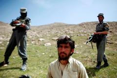 Policisté se zatčeným příslušníkem Tálibánu v provincii Zábul na jihovýchodě Afghánistánu.