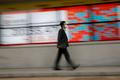 FILE PHOTO: A man wearing a protective face mask, following the coronavirus disease (COVID-19) outbreak, walks in front of a stock quotation board outside a brokerage in Tokyo