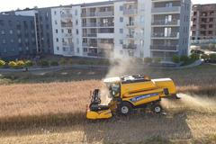 Sklizeň uprostřed sídliště. Polský farmář odmítl prodat svá pole, dál tak farmaří mezi paneláky